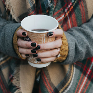 woman holding coffee cup wearing cushion cut engagement ring