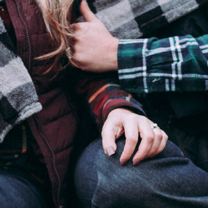 woman wearing engagement ring with hand on fiance's leg